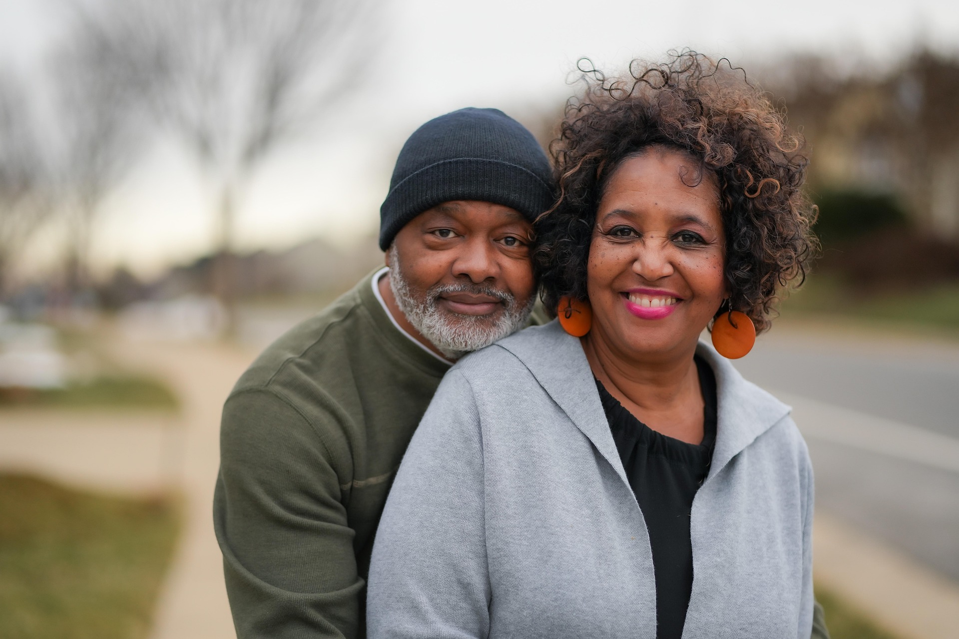 Smiling mature couple embracing outdoors, representing emotional support, healthy relationships, and positive mental well-being.